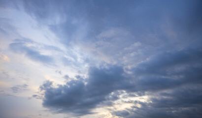 Obraz premium Dramatic sky at dusk with dark, textured clouds and golden rays peeking through