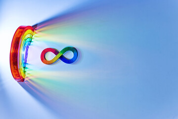 Infinity symbol with rainbow light spectrum on blue. Autism awareness,