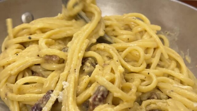 Woman with red nails eating delicious creamy spaghetti with a fork and spoon, with a healthy avocado burger and fresh juice on the restaurant table, revealing a focus on modern cuisine.4k