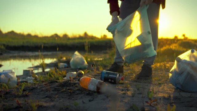 A dedicated male volunteer diligently collects and sorts plastic bottles and refuse on a serene pond shore at dusk, exemplifying sustainable waste disposal and nature protection efforts