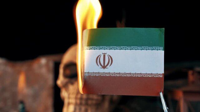 Close-up of an iranian flag burning against a dark background with a blurred human skull, symbolizing protest, revolution, and death