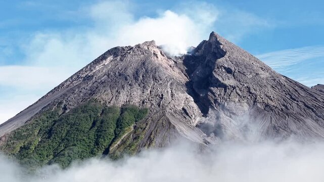 4K aerial footage showing the peak of Mount Merapi Yogyakarta, with clear blue sky.