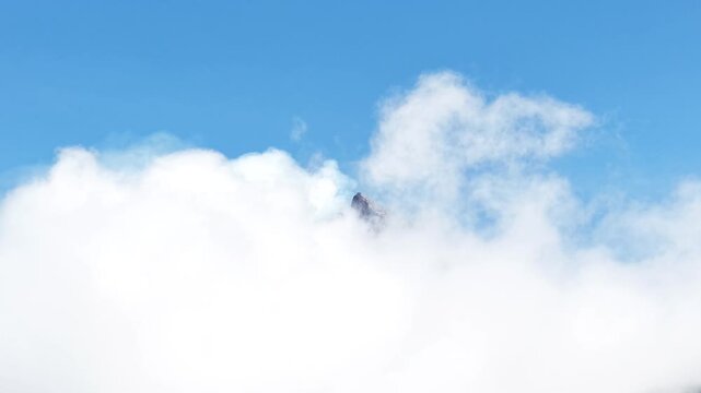 4K aerial footage shows the peak of Mount Merapi in Yogyakarta covered in thick clouds, with clear blue skies.