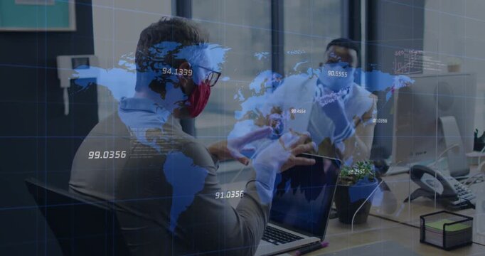 World map over two diverse male office colleagues wearing face masks discussing at office