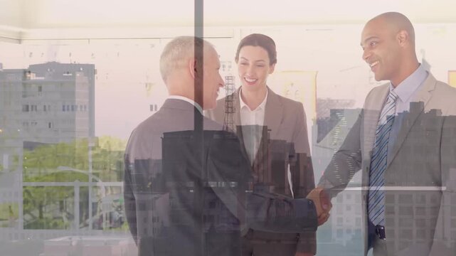 Composite video of diverse businesspeople shaking hands against aerial view of cityscape