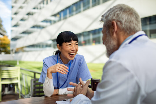 Healthcare coworkers chatting outdoors at hospital
