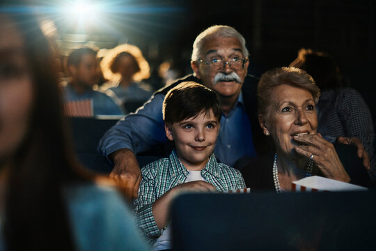Grandparents and grandson watching a movie at the cinema