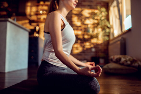 Young woman practicing yoga meditation at home