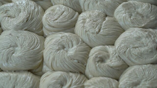 Traditional production of handmade rice noodles showing rows of coiled vermicelli drying, a classic staple food of vietnamese and asian culinary heritage