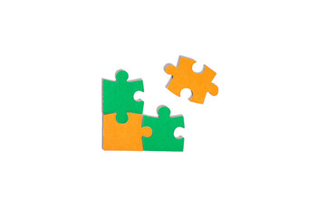 Naklejka premium Orange and green puzzle pieces scattered on white background, flat lay. Puzzle, pieces, orange, green, scattered, white.