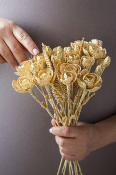 Wedding bouquet of flowers made of straw in female hands