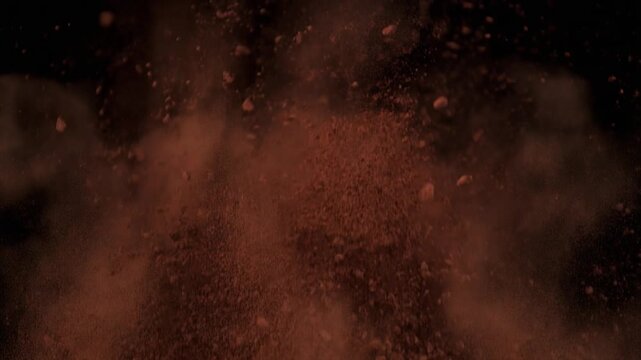 Brown particles explode in darkness.