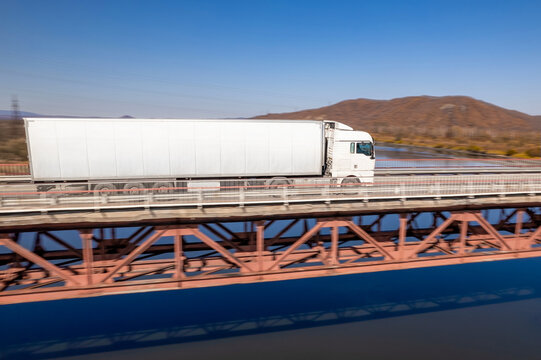 White truck on a bridge over the river