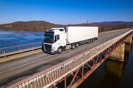 White truck on a bridge over the river