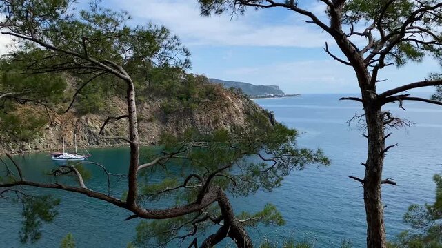Panoramic view of the calm Mediterranean Sea and yacht among the mountains near Camyuva, Kemer, Turkey. 4k