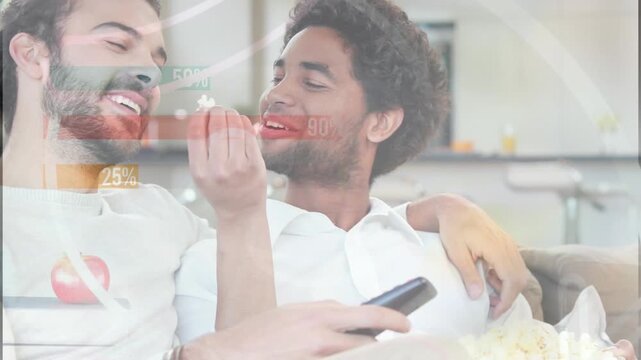 Animation of media icons over diverse male couple using watching tv