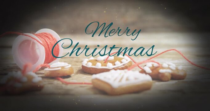 Animation of merry christmas text banner against christmas cookies and thread on wooden surface