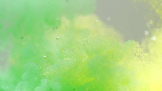 Green and yellow paint cloud spreading in water on a white background. Premium marketing concept for overlay effects, creative branding, banner and advertising layout design, ecology, beauty, and