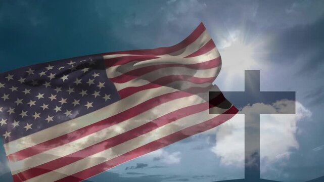 Waving American flag over cross with bright sun and clouds in background