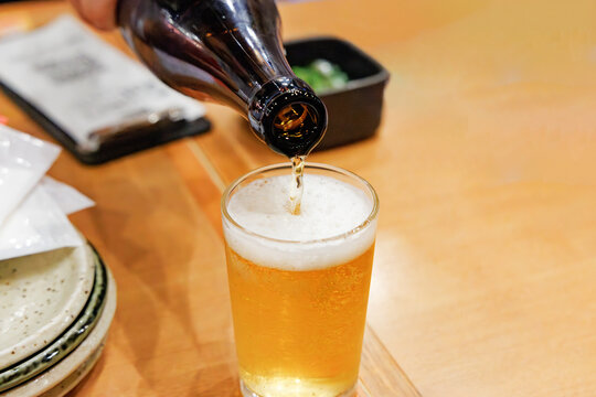 瓶ビールからグラスへ注がれる黄金色のビール