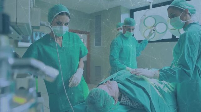 Surgical team adjusting light and checking IV as animated vital signs updating monitor for surgery