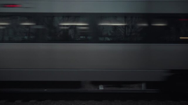 A high-speed passenger train hurtles along the railway track, embodying rapid motion on the rail surface as it traverses between stations, exemplifying efficient transport and travel