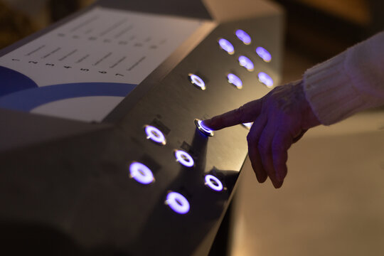 A quiz for visitors to an exhibition or museum, where a finger presses a button to answer or obtain information on a stand.