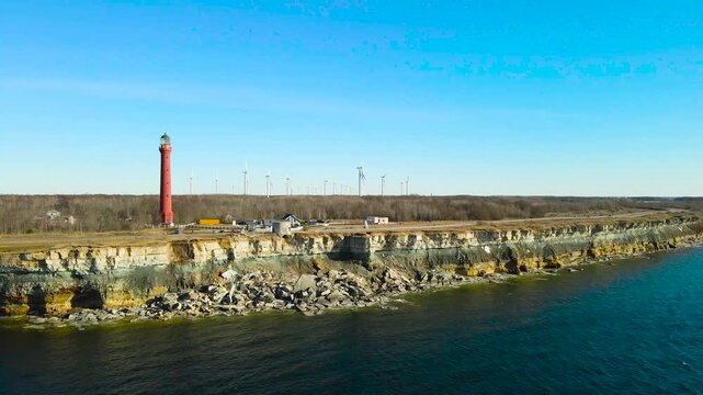 Aerial flight over Pakri cliff with lighthouse and wind turbines