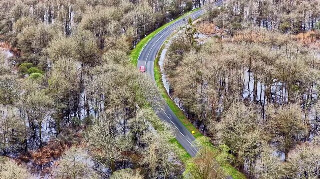 Aerial view of red car on road in flooded Briere Regional Natural Park