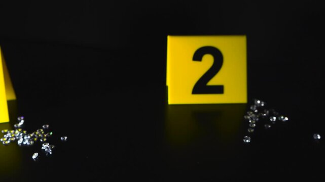 Diamonds and crime scene evidence markers on black background
