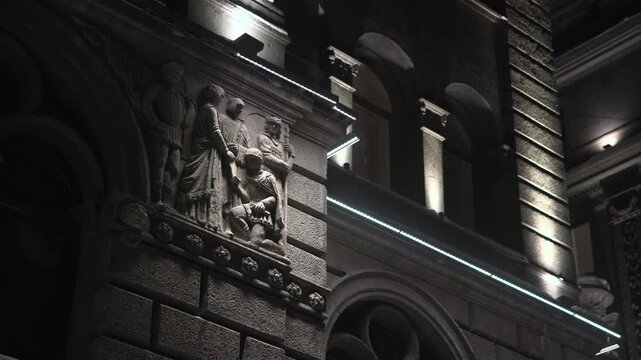 Closeup Of Expressive Stone Sculptures Illuminated By Architectural Lighting In Urban Night Scene. Media