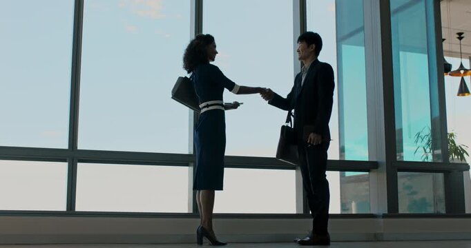 Business, folder or people in agency with handshake, greeting or meeting for b2b deal. Networking, introduction or employees in workplace with file, agreement or opportunity for partnership.