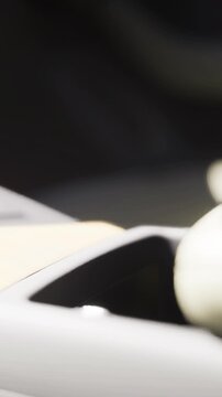 A cup is placed in a holder inside a car. The sunlight shines on the cup, showing a simple moment during a drive. The scene displays daily life in motion and routine.