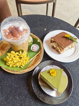Indulge in a delightful cafe experience featuring a refreshing iced strawberry coffee, a classic tiramisu, and a vibrant matcha cheesecake. Perfect for a cozy afternoon treat or sharing with friends.