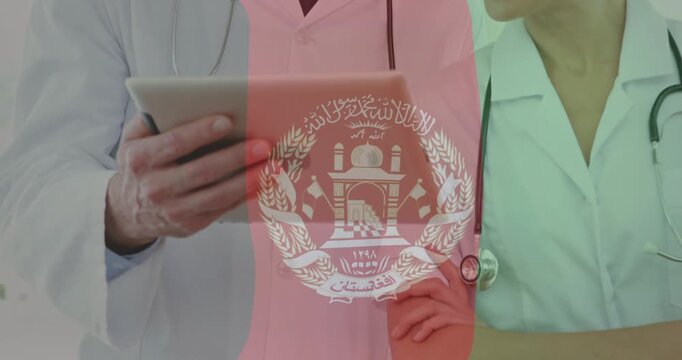 Using tablet, doctors with stethoscopes and Afghanistan emblem overlay in animation