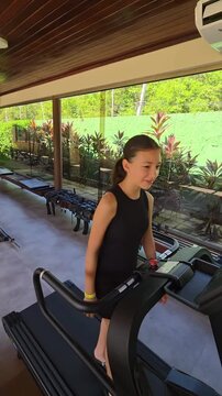 adolescente faz treino em esteira de academia 