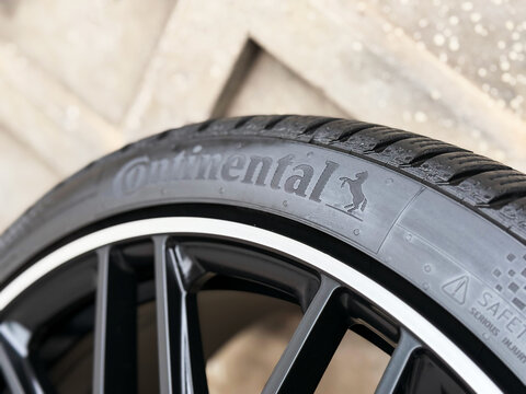 New car tires Continental on blurred grey background. Continental is a German manufacturer of tires and auto components. Seasonal tire change. Horse logo at Continental car tires.