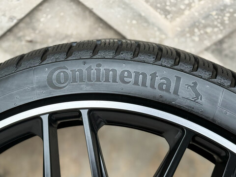 New car tires Continental on blurred grey background. Continental is a German manufacturer of tires and auto components. Seasonal tire change. Horse logo at Continental car tires.
