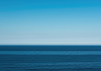 Obraz premium A vast, simple scene showing the meeting point of the calm, deep ocean and the clear, expansive blue sky, creating an ideal minimalist background, open, clear, peaceful
