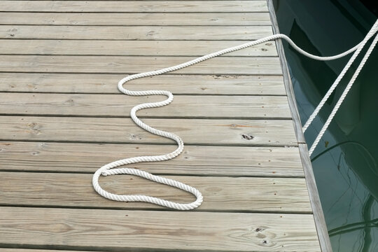 Antigua,West Indies. Boat rope arranged on wooden dock near water edge
