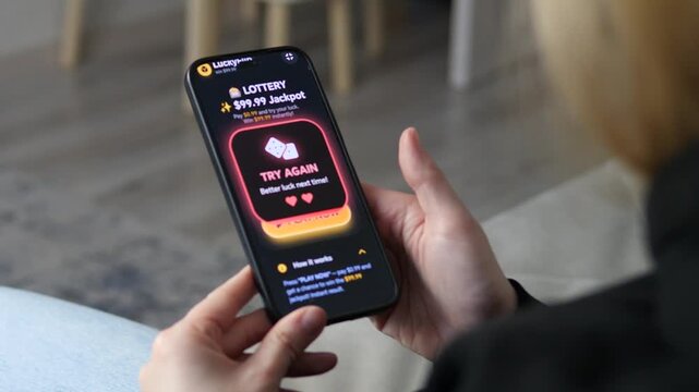Smartphone Screen with Online Casino App and Losing Result. Close-up of sleek mobile gambling UI. User attempts to win a jackpot but gets a Try Again notification. Ideal for app reviews and modern