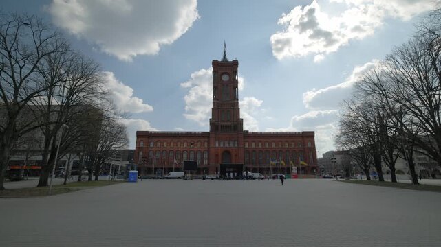 BERLIN, GERMANY - MARCH 23 2026: Panning shot of the Rotes Rathaus (Red Town Hall), the seat of the governing mayor of Berlin, featuring its red brick architecture and clock tower under a cloudy blue 