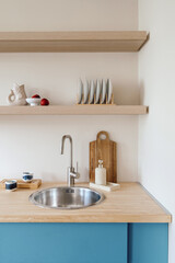 Modern kitchen area with minimalist sink, faucet and wooden countertop