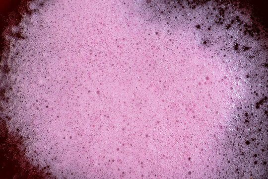 Pink fermentation foam texture with dense bubbles beverage surface macro
