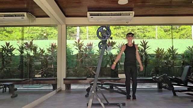 homem faz exerc&iacute;cios fis&iacute;cos em academia 