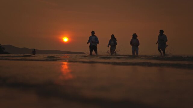 Families playfully running on the beach at sunset celebrate summer travel, freedom, and the blissful seaside lifestyle