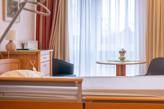 Modern medical bed in hospital, nursing home bed with wooden frame, adjustable metal side rail, emergency call button, elder care, rehabilitation infrastructure, comfortable rehabilitation room