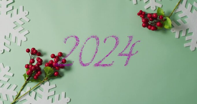 Animation of purple 2024 text banner over red berries and snowflakes cutouts on grey background