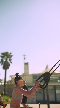Demonstrating proper form and steady tempo during workout at beachside gym