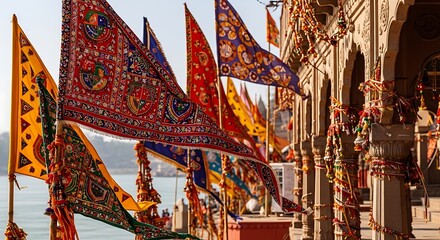 Fototapeta premium Colorful Indian flags with intricate patterns and embellishments flutter in breeze outside ancient temple.